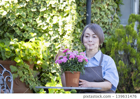 老年婦女們在自家院子裡享受園藝的樂趣 老年婦女們在自家院子裡享受園藝的樂趣 139631476
