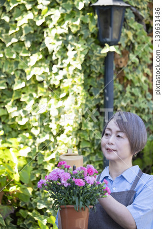 老年婦女們在自家院子裡享受園藝的樂趣 老年婦女們在自家院子裡享受園藝的樂趣 139631486