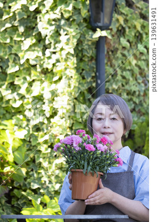 Senior women enjoying gardening in their yards Senior women enjoying gardening in their yards 139631491