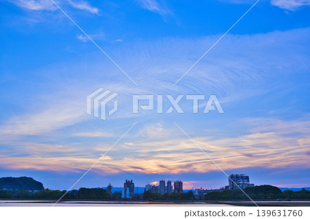 黃昏時分,一列火車駛過工業區。 黃昏時分,一列火車駛過工業區。 139631760