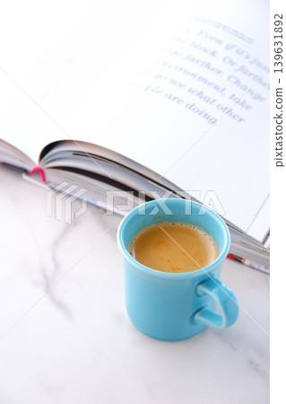 An image of enjoying reading while drinking coffee with an open book (Western book) and a coffee cup with coffee in it. An image of enjoying reading while drinking coffee with an open book (Western book) and a coffee cup with coffee in it. 139631892