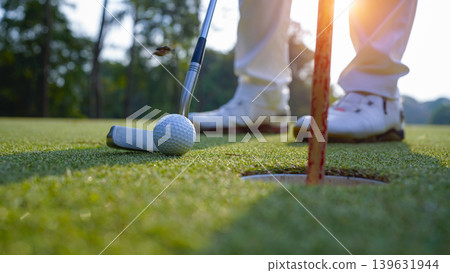 Golfers are putting golf in the evening golf course golf backglound. Golfers are putting golf in the evening golf course golf backglound. 139631944