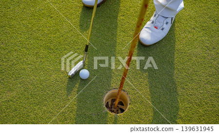 Golfers are putting golf in the evening golf course golf backglound. Golfers are putting golf in the evening golf course golf backglound. 139631945