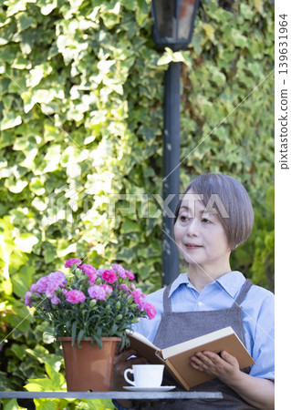 A senior woman reading in the garden 139631964
