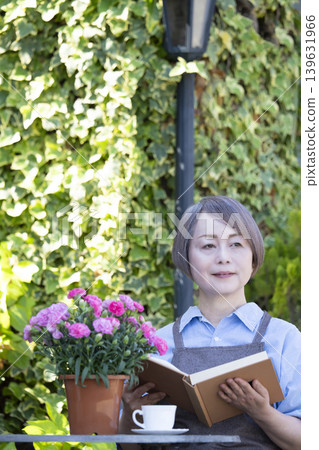 一位老婦人在花園裡讀書 139631966