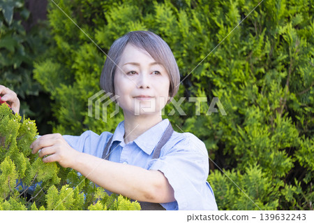 老年婦女們在自家院子裡享受園藝的樂趣 老年婦女們在自家院子裡享受園藝的樂趣 139632243