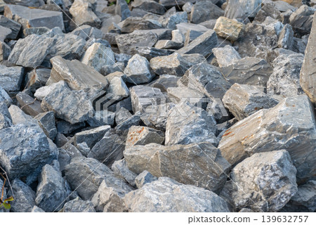 Pile of gray stone rocks with rough natural texture and layered mineral surface ideal for construction geology and abstract background use Pile of gray stone rocks with rough natural texture and layered mineral surface ideal for construction geology and abstract background use 139632757