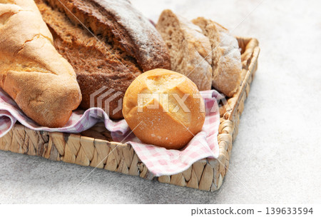Assorted fresh crusty bread loaves in rustic basket Assorted fresh crusty bread loaves in rustic basket 139633594