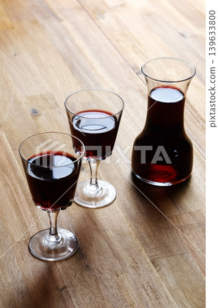 Toasting with red wine - Image of two wine glasses filled with red wine making a toast Toasting with red wine - Image of two wine glasses filled with red wine making a toast 139633800