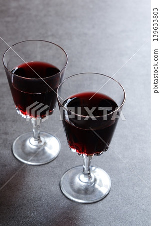 Toasting with red wine - Image of two wine glasses filled with red wine making a toast 139633803