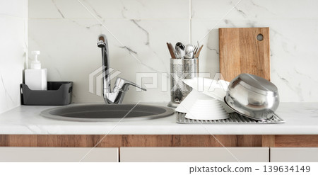 Clean dishes on drying rack in modern kitchen Clean dishes on drying rack in modern kitchen 139634149