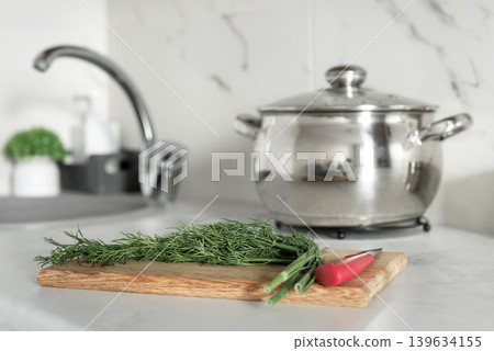 Fresh herbs and saucepan in bright modern kitchen Fresh herbs and saucepan in bright modern kitchen 139634155