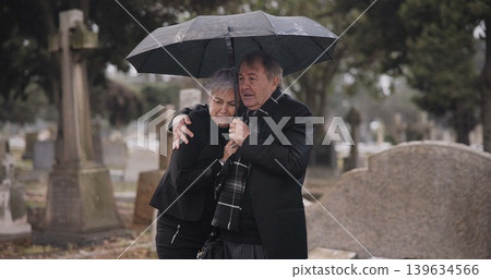 Support, death or old couple in cemetery for funeral, service or burial for repsect in Christian religion. Umbrella, depressed or sad senior people hug for comfort in graveyard crying in mourning Support, death or old couple in cemetery for funeral, service or burial for repsect in Christian religion. Umbrella, depressed or sad senior people hug for comfort in graveyard crying in mourning 139634566