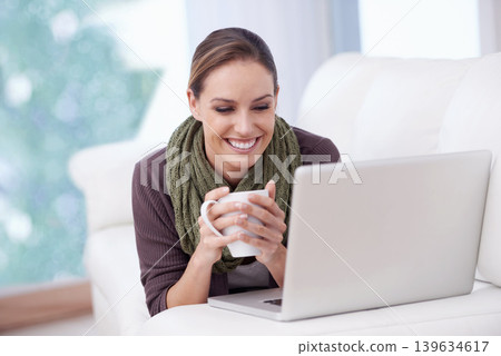 Laptop, relax and happy woman on a sofa with coffee while streaming movie, film or video at home. Pc, smile or female person in a living room with tea, break or social media, subscription or show 139634617