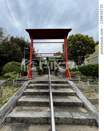 Toukeino Shrine: Stone steps, a stone torii gate with a plaque in front of the approach that crosses the Meishin Expressway, and a red torii gate further in front of it. Toukeino Shrine: Stone steps, a stone torii gate with a plaque in front of the approach that crosses the Meishin Expressway, and a red torii gate further in front of it. 139634735