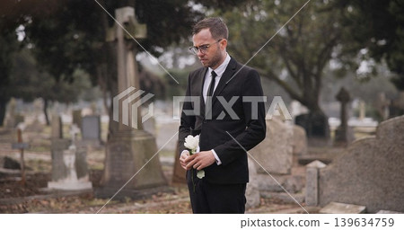 Funeral, cemetery and man with flower by tombstone for remembrance, burial ceremony and memorial service. Depression, sad and person with rose by gravestone for mourning, grief and loss in graveyard Funeral, cemetery and man with flower by tombstone for remembrance, burial ceremony and memorial service. Depression, sad and person with rose by gravestone for mourning, grief and loss in graveyard 139634759