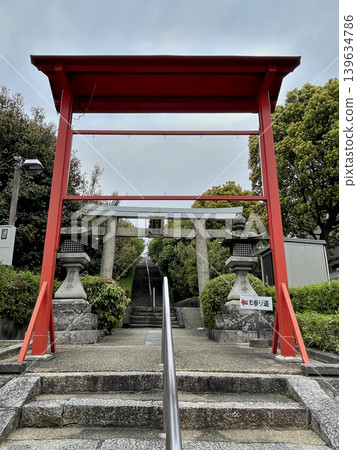 Toukeino Shrine: Stone steps, a stone torii gate with a plaque in front of the approach that crosses the Meishin Expressway, and a red torii gate further in front of it. Toukeino Shrine: Stone steps, a stone torii gate with a plaque in front of the approach that crosses the Meishin Expressway, and a red torii gate further in front of it. 139634786