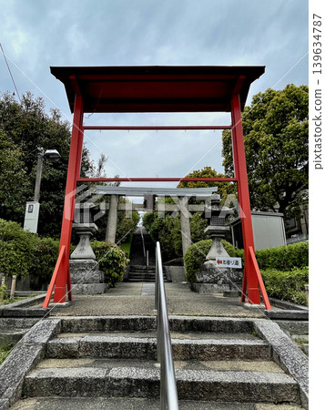 Toukeino Shrine: Stone steps, a stone torii gate with a plaque in front of the approach that crosses the Meishin Expressway, and a red torii gate further in front of it. 139634787