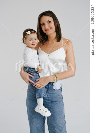 Young Mother Carrying Toddler Girl and Smiling Young Mother Carrying Toddler Girl and Smiling 139635324