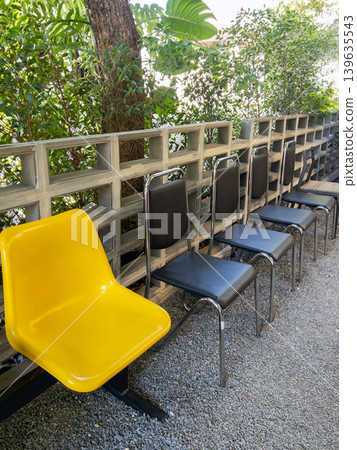 Outdoor Waiting Chairs with Yellow Seat in Garden Setting. 139635543