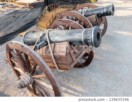 Antique Cast Iron Cannons on Rustic Wooden Carriages, Historical Military Display Antique Cast Iron Cannons on Rustic Wooden Carriages, Historical Military Display 139635546