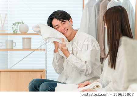一對面帶微笑的夫婦在客廳裡疊衣服 139635907