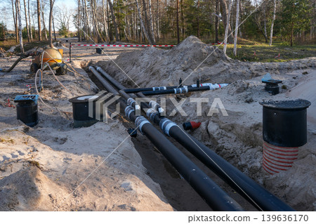 Insulated underground utility pipes installed in trench for district heating construction project 139636170
