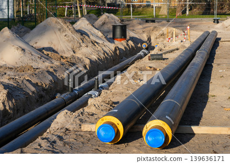 Pre-insulated underground heating pipes prepared for district heating network installation site 139636171