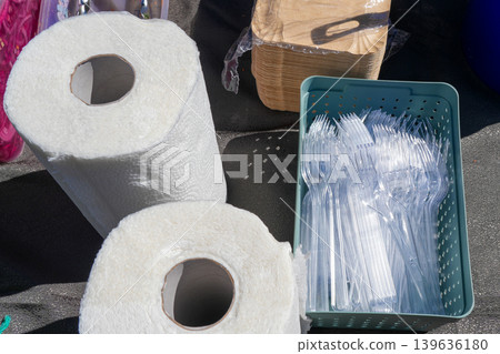 Disposable paper towels and plastic forks arranged on table for outdoor catering and food service Disposable paper towels and plastic forks arranged on table for outdoor catering and food service 139636180