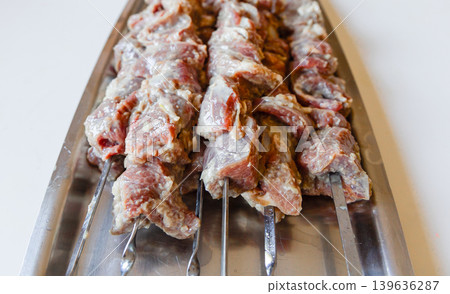 Fresh marinated lamb meat on metal skewers ready for grill cooking. Fresh marinated lamb meat on metal skewers ready for grill cooking. 139636287