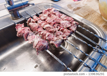 Fresh marinated lamb meat on metal skewers ready for grill cooking. 139636291