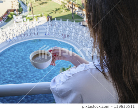 woman drinking coffee in hotel room with pool view woman drinking coffee in hotel room with pool view 139636511
