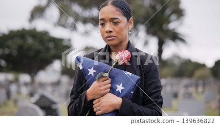 Funeral, death and rose for a woman with a flag at a cemetery in mourning at a memorial service. Sad, usa and an army wife as a widow with a flower in a graveyard feeling the pain of loss or grief Funeral, death and rose for a woman with a flag at a cemetery in mourning at a memorial service. Sad, usa and an army wife as a widow with a flower in a graveyard feeling the pain of loss or grief 139636822