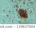 Large Rust Spot on Turquoise Metal Surface: Corroded Paint Texture with Brown Oxidation. Vintage Grunge Background 139637004