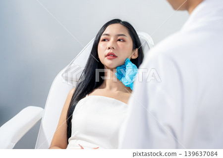 Asian woman consulting with a doctor at a modern aesthetic clinic for facial treatment. 139637084