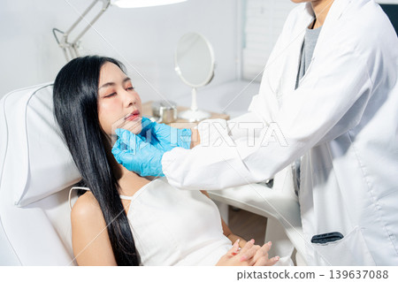 Asian woman consulting with a doctor at a modern aesthetic clinic for facial treatment. 139637088