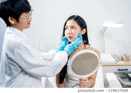 Asian woman consulting with a doctor at a modern aesthetic clinic for facial treatment. Asian woman consulting with a doctor at a modern aesthetic clinic for facial treatment. 139637089