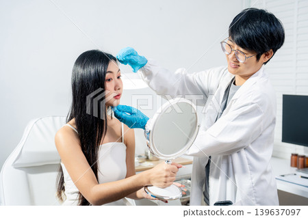 Asian woman consulting with a doctor at a modern aesthetic clinic for facial treatment. Asian woman consulting with a doctor at a modern aesthetic clinic for facial treatment. 139637097
