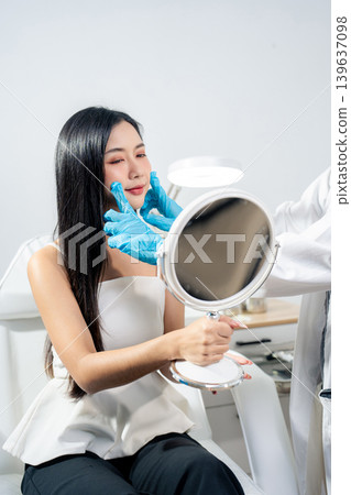 Asian woman consulting with a doctor at a modern aesthetic clinic for facial treatment. 139637098