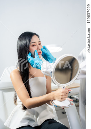 Asian woman consulting with a doctor at a modern aesthetic clinic for facial treatment. 139637099