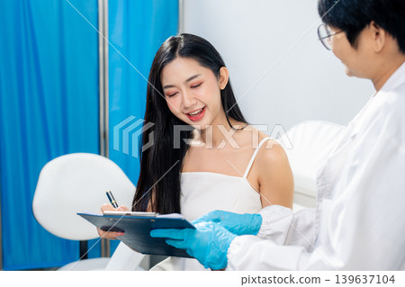 Asian woman consulting with a doctor at a modern aesthetic clinic for facial treatment. 139637104