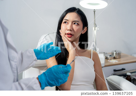 Asian woman consulting with a doctor at a modern aesthetic clinic for facial treatment. 139637105