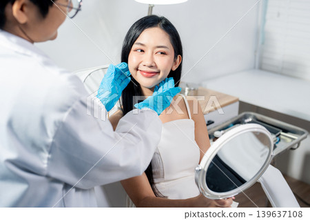 Asian woman consulting with a doctor at a modern aesthetic clinic for facial treatment. Asian woman consulting with a doctor at a modern aesthetic clinic for facial treatment. 139637108