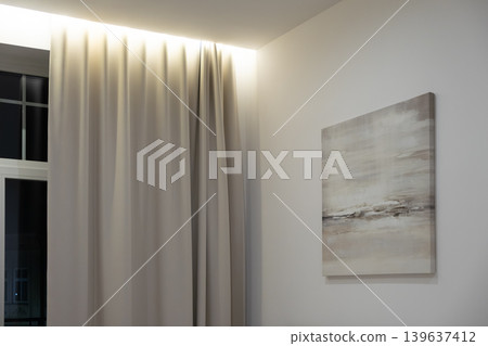 Minimalist interior featuring modern abstract canvas art and soft draped curtains with warm ceiling lighting, reflecting contemporary elegance and comfort in a luxury living space Minimalist interior featuring modern abstract canvas art and soft draped curtains with warm ceiling lighting, reflecting contemporary elegance and comfort in a luxury living space 139637412