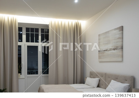Modern bedroom interior with neutral tones, elegant curtains and soft ambient lighting, highlighting a cozy atmosphere for luxury apartment living or high end hotel design projects 139637413
