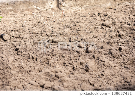 Close up of tilled soil in an agricultural field, showing rough textured earth ready for planting during the spring season for farming cultivation and sustainable crop growth Close up of tilled soil in an agricultural field, showing rough textured earth ready for planting during the spring season for farming cultivation and sustainable crop growth 139637451