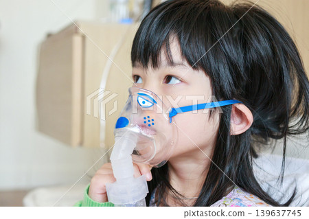 Sick little asian girl inhalation with nebulizer for respiratory treatment Sick little asian girl inhalation with nebulizer for respiratory treatment 139637745