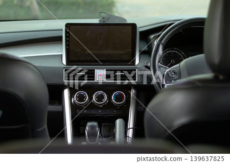Modern car interior with touchscreen dashboard, steering wheel and climate control system showcasing contemporary automotive technology and transportation design. 139637825