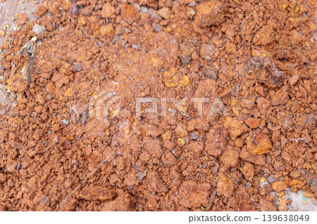 Close up view of red soil texture with granular clumps, representing natural land erosion, geological formation, or agricultural ground conditions for environmental and gardening projects 139638049