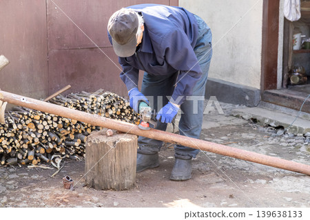 A skilled worker uses a professional angle grinder to polish a rusted metal pipe outdoors, focusing on precise metalworking craftsmanship and hardware repair tasks in a workshop setting A skilled worker uses a professional angle grinder to polish a rusted metal pipe outdoors, focusing on precise metalworking craftsmanship and hardware repair tasks in a workshop setting 139638133